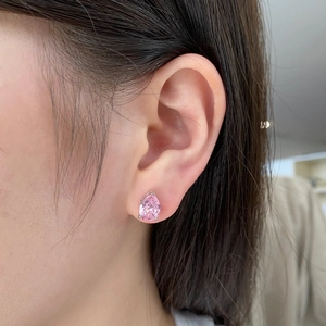 Detail of a pear-cut pink zircon stud earring in S925 sterling silver on ear