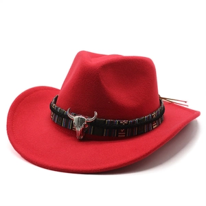 Detail of red cowboy hat featuring ethnic woven band and silver bull skull metal ornament