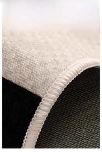 Detail of minimalist rug showing premium hand-stitched edges and anti-slip backing
