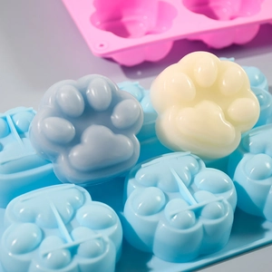 Close-up of 6-cavity cat paw silicone mold with light blue and cream resin finished pieces