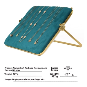 Detail view of emerald green velvet jewelry display tray with elegant gold frame accents