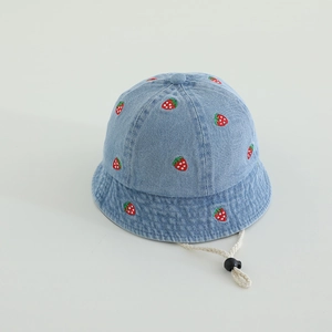 Detail of blue denim baby sun hat featuring red strawberry embroidery and adjustable chin strap