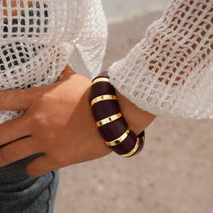 Détail d'un bracelet manchette large avec maillons en acrylique bordeaux et métal doré