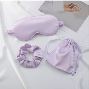 Close-up of three-piece purple satin sleep set with eye mask, scrunchie and drawstring pouch