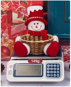 Detailed view of handmade snowman Christmas candy basket showing 149g weight on scale