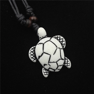 Resin sea turtle pendant necklace with black cord and brown wooden beads on black background