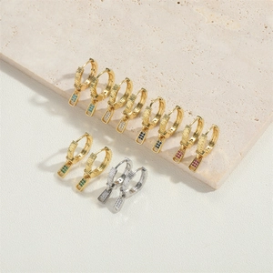 Flat lay of small 14K gold plated earrings with colorful zircon stones on textured stone