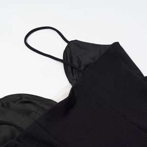 Detail shot of black polka dot dress featuring adjustable spaghetti straps and neckline