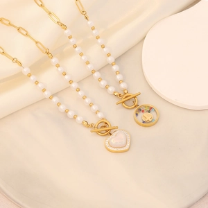 Macro detail of gold pearl necklaces with heart and cross pendants on silk background