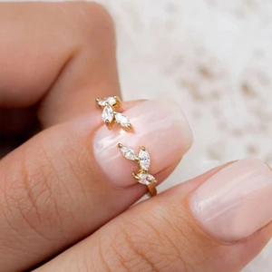 Close-up of gold-plated leaf ring with marquise-cut zircons worn on a finger