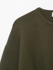 Macro shot of army green knit fabric showing neck collar and detailed stitching