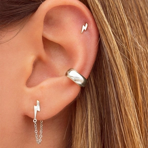 Close-up of silver ear cuff and lightning bolt studs set worn on model's ear