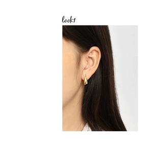 Macro shot of minimalist gold teardrop earrings showing smooth polished finish and fit