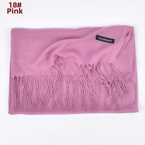 Detail shot of the dusty pink cashmere scarf featuring soft fringe and woven brand label