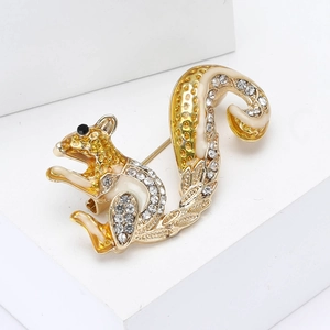 Creative squirrel brooch in gold alloy with clear rhinestones on white cube pedestal