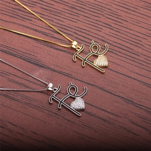 Gold and silver Fu character heart necklaces with cubic zirconia on a wood background
