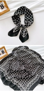 Detail of black and white cross-grid silk scarf showing tied style and flat geometry layout
