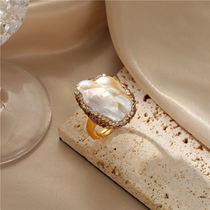 Detailed macro view of a Baroque pearl ring with zircon halo on a gold adjustable band