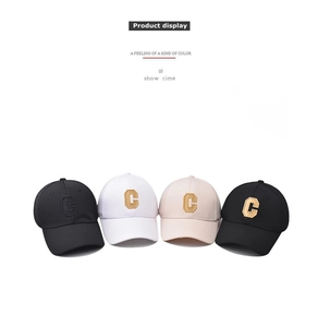 Detail of multi-color baseball caps with large embroidered C letter on cotton fabric