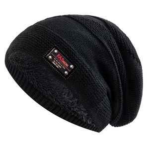 Detail of black knit beanie featuring warm grey faux fur lining and fashion leather patch