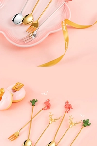 Close-up of golden and silver stainless steel dessert spoons with creative motifs