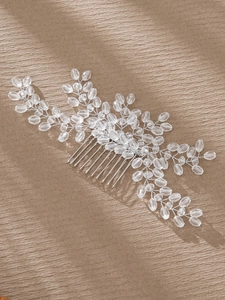 Close-up of handmade bridal hair comb with silver wire floral beads and crystal leaves