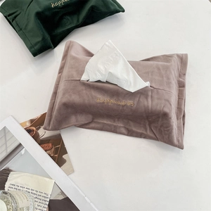 Close-up of velvet tissue bag with Happiness gold embroidery and soft plush texture
