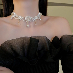 Detail of floral choker necklace with white pearls and crystals worn on a model neck