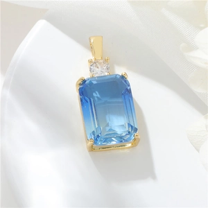 Detailed close-up of a blue rectangle gemstone pendant with gold-plated setting and zircon