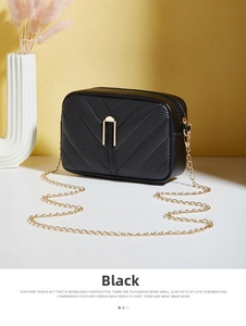 Detailed view of black crossbody bag with V-shaped stitching and golden metal chain lock