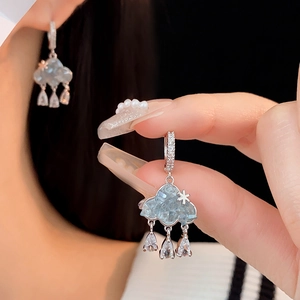 Gros plan de boucles d'oreilles nuage en argent avec gouttes d'eau en zircon et petite étoile