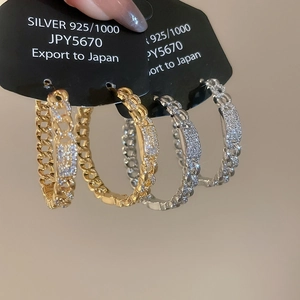 Detailed macro view of S925 silver chunky chain hoop earrings with cubic zirconia inlay
