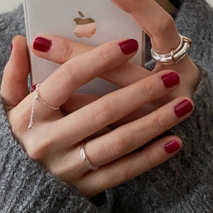 Detail of minimalist 925 silver rings with chain and gold accents on model hand