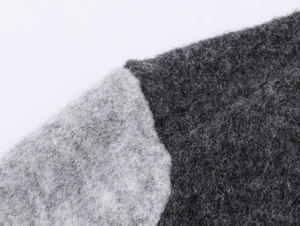 Close-up of contrast knit fabric showing soft mohair texture and grey stitching details