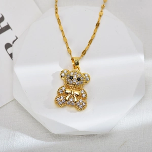 Detail shot of a gold bear pendant with white zircons on a white geometric display