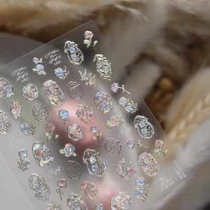 Macro shot of laser holographic rose nail stickers with vintage frame on feather