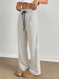 Detailed view of elastic waist with black drawstring on striped wide leg trousers