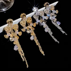Elegant floral drop earrings with sparkling crystals and long tassels on a black display
