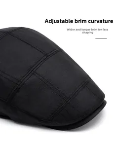 Close-up of black newsboy cap featuring micro-grid texture and foldable curved brim
