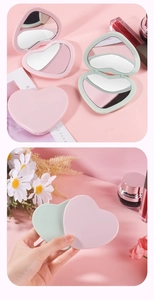 Close-up of pink and green heart-shaped compact mirrors with a portable folding flip design