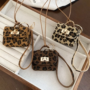 Close-up of leopard print mini bag pendants with metal locks and suede texture details
