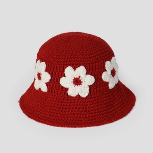 Détail du chapeau cloche rouge au crochet avec de petites fleurs blanches tricotées
