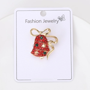 Detail of a Christmas bell brooch with red rhinestones and gold alloy metal base