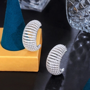 Detailed close-up of silver C-shaped hoop earrings with shimmering pave-set cubic zirconia