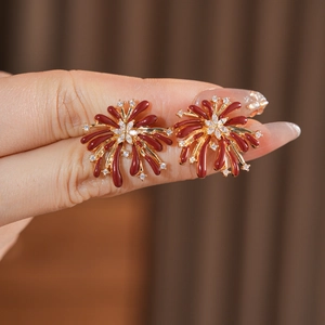 Vue détaillée des boucles d'oreilles fleur avec émail brun-rouge et pierres en zircon blanc