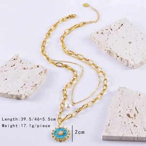 Detail of gold double-layer necklace with pearl and turquoise sun pendant on stone