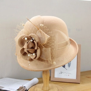 Détail du chapeau cloche en laine avec fleur de camélia et perles blanches élégantes