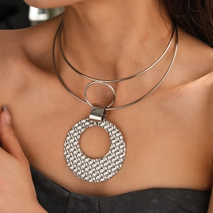 Close-up of a silver layered choker featuring a large textured round pendant on model