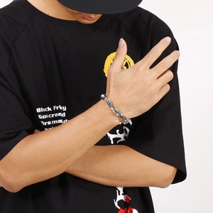 Close-up of men's silver geometric chain bracelet worn on wrist with industrial style