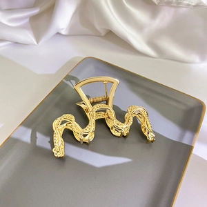 Detaillierte Nahaufnahme einer goldenen Haarspange aus Metall mit gedrehter Seilstruktur